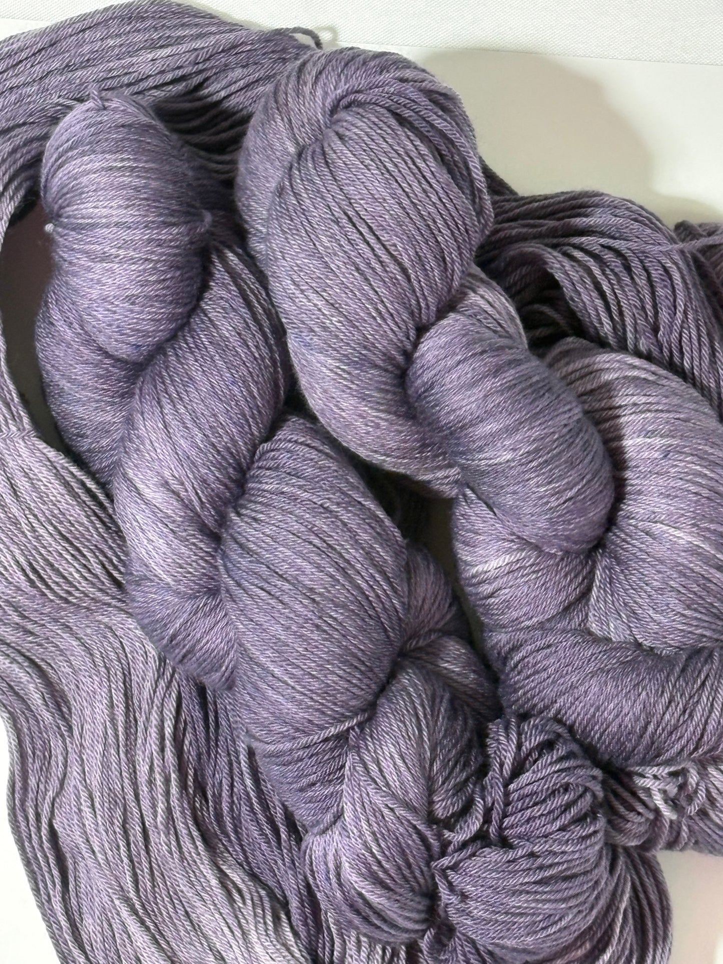 A smoky, softened violet hand-dyed tonal yarn with subtle gray undertones, Nightfall Violet captures the hush of dusk as daylight fades into evening. Calm, contemplative, and endlessly wearable.
