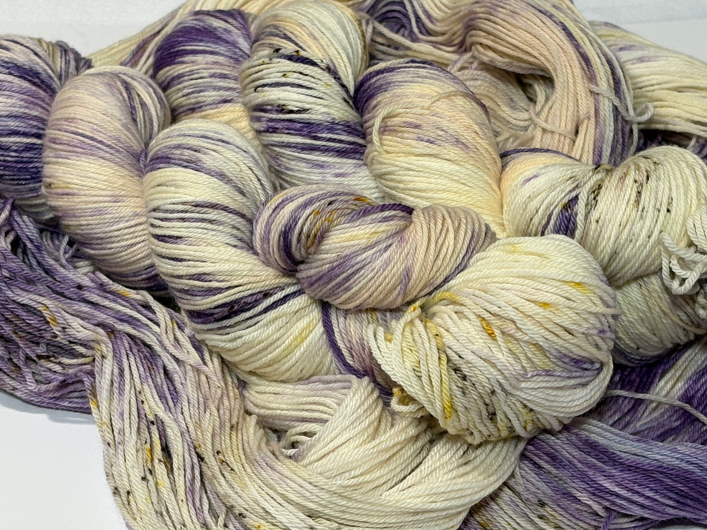 A luminous cream base multicolored hand-dyed yarn brushed with soft lilac and delicate golden speckles. Enchanted Winterlight captures the quiet magic of winter light through old glass.
