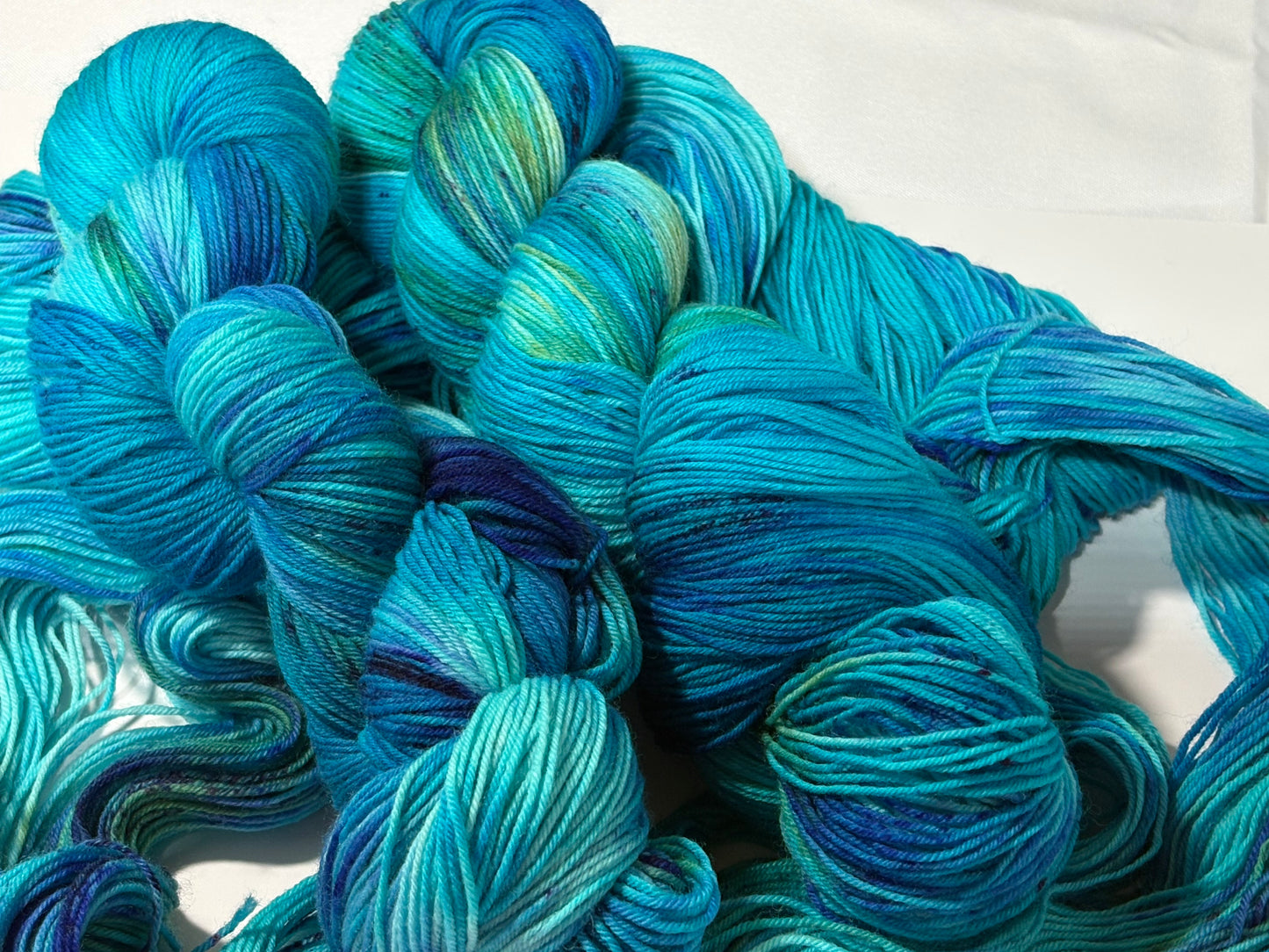 A flowing blend of teal, aqua, and deep blue inspired by winter rivers at dusk. Winter Twilight River is a hand-dyed yarn that is cool, dynamic, and full of movement.