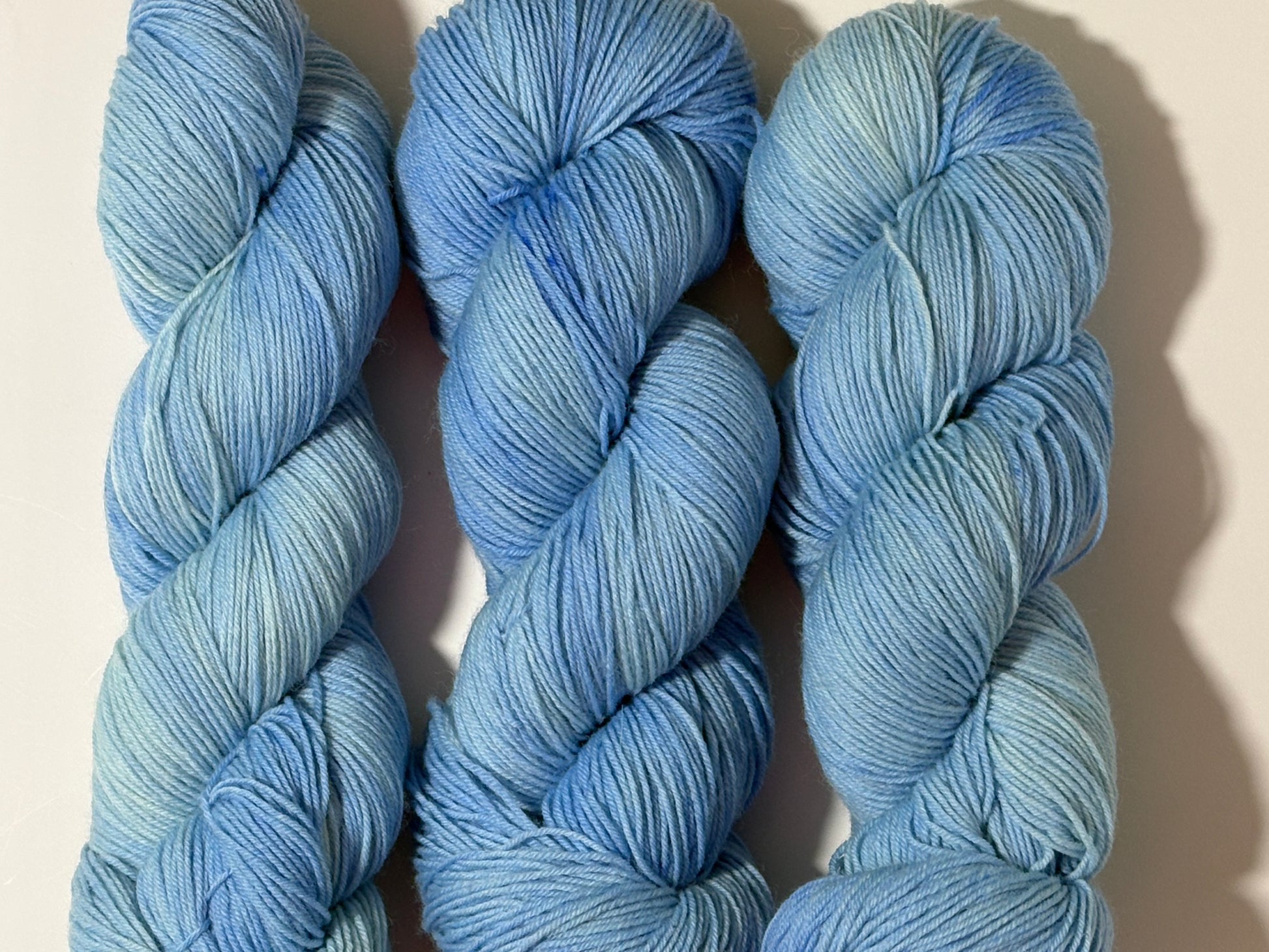 A soft icy blue hand-dyed tonal yarn inspired by frost-covered winter paths and quiet cold mornings.