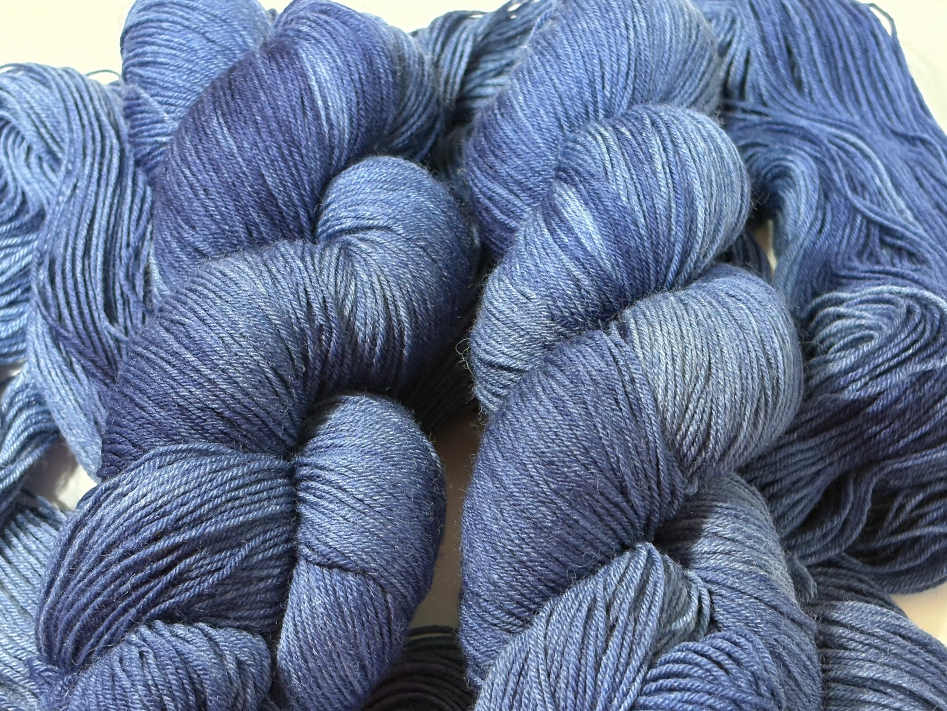 A deep, tonal blue hand-dyed yarn inspired by the quiet moment when daylight fades and night settles in.