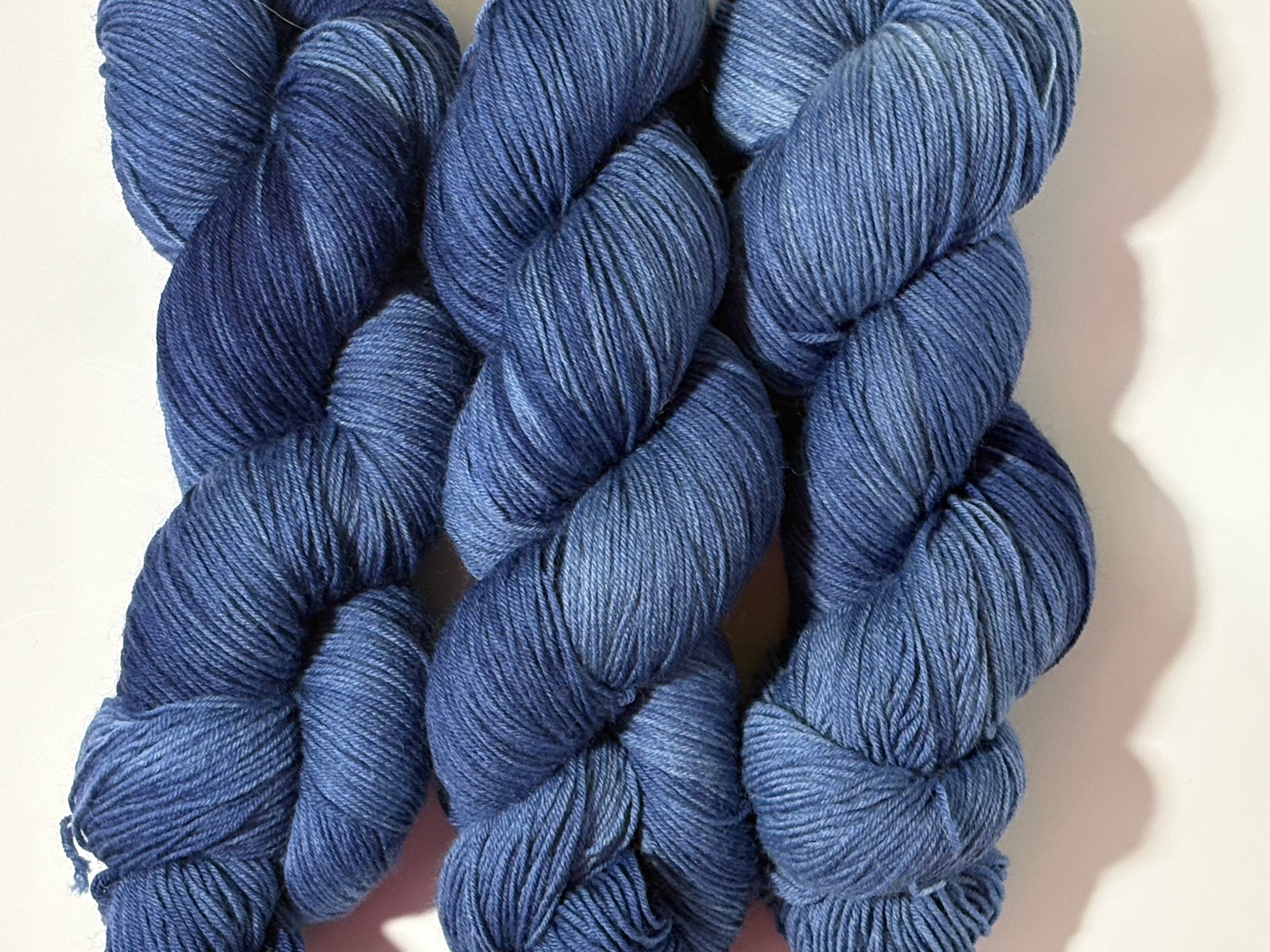 A deep, tonal blue hand-dyed yarn inspired by the quiet moment when daylight fades and night settles in.