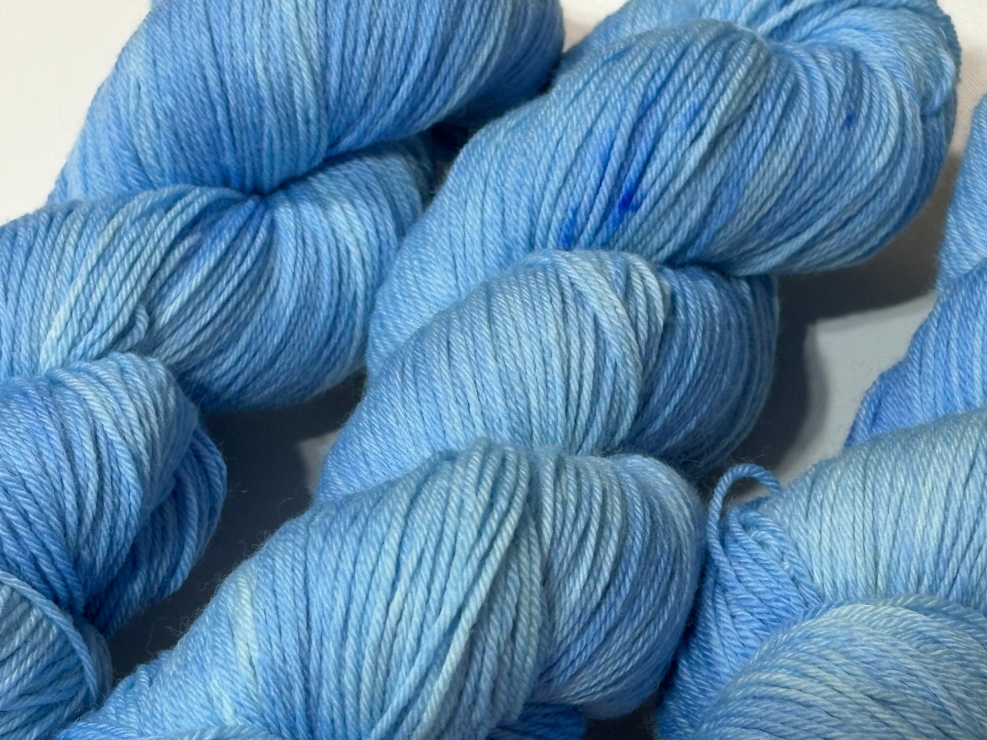 A soft icy blue hand-dyed tonal yarn inspired by frost-covered winter paths and quiet cold mornings.