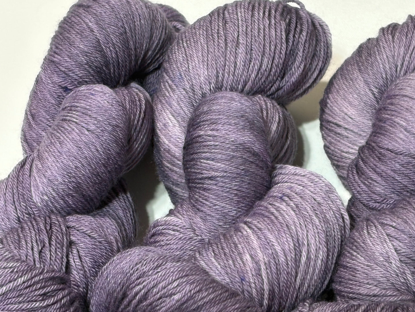 A smoky, softened violet hand-dyed tonal yarn with subtle gray undertones, Nightfall Violet captures the hush of dusk as daylight fades into evening. Calm, contemplative, and endlessly wearable.