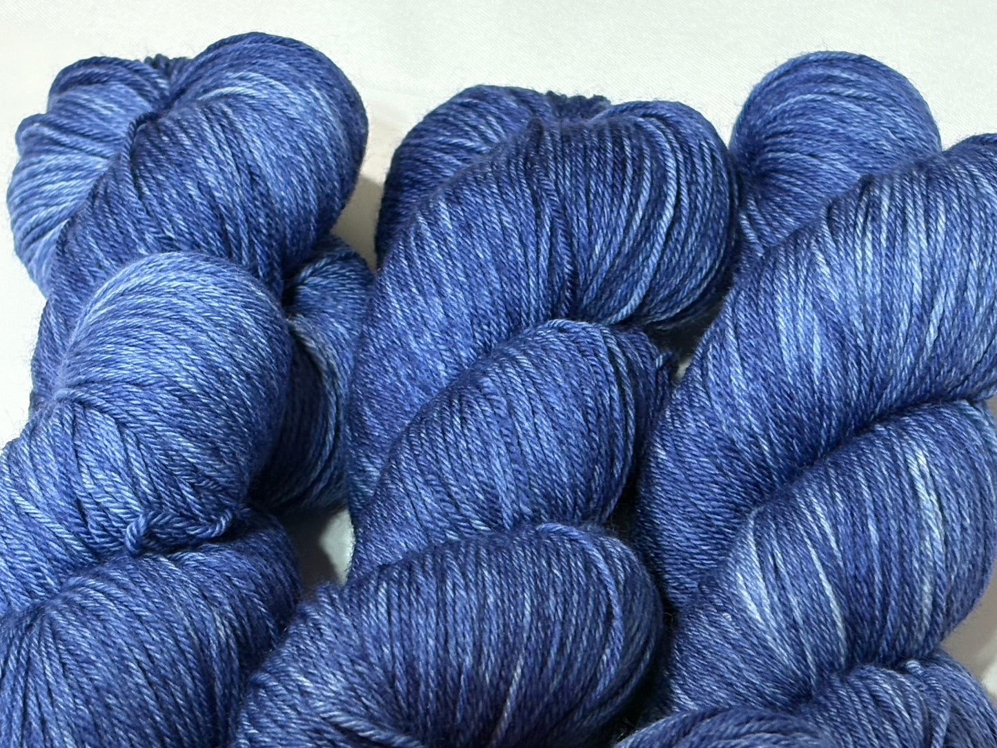 A deep, tonal blue hand-dyed yarn inspired by the quiet moment when daylight fades and night settles in.