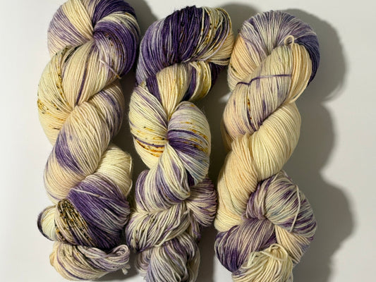 A luminous cream hand-dyed yarn brushed with soft lilac and delicate golden speckles. Enchanted Winterlight captures the quiet magic of winter light through old glass.