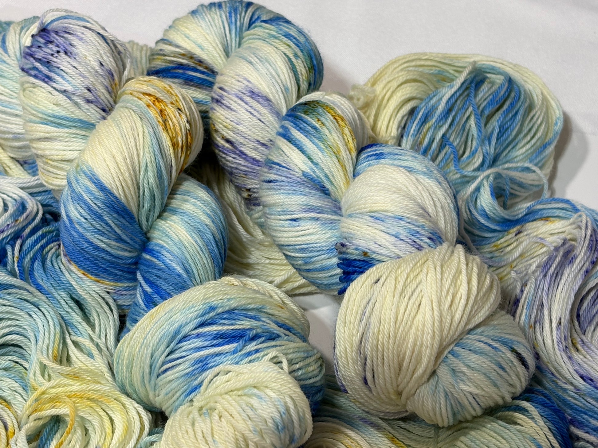 A softly speckled winter hand-dyed yarn colorway inspired by quiet woodland paths dusted with frost and snow.
