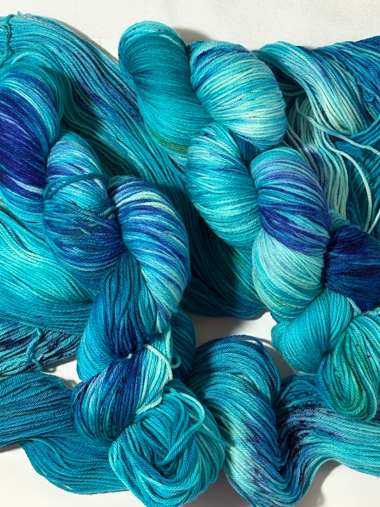 A flowing blend of teal, aqua, and deep blue multicolored hand-dyed yarn inspired by winter rivers at dusk. Winter Twilight River is cool, dynamic, and full of movement.