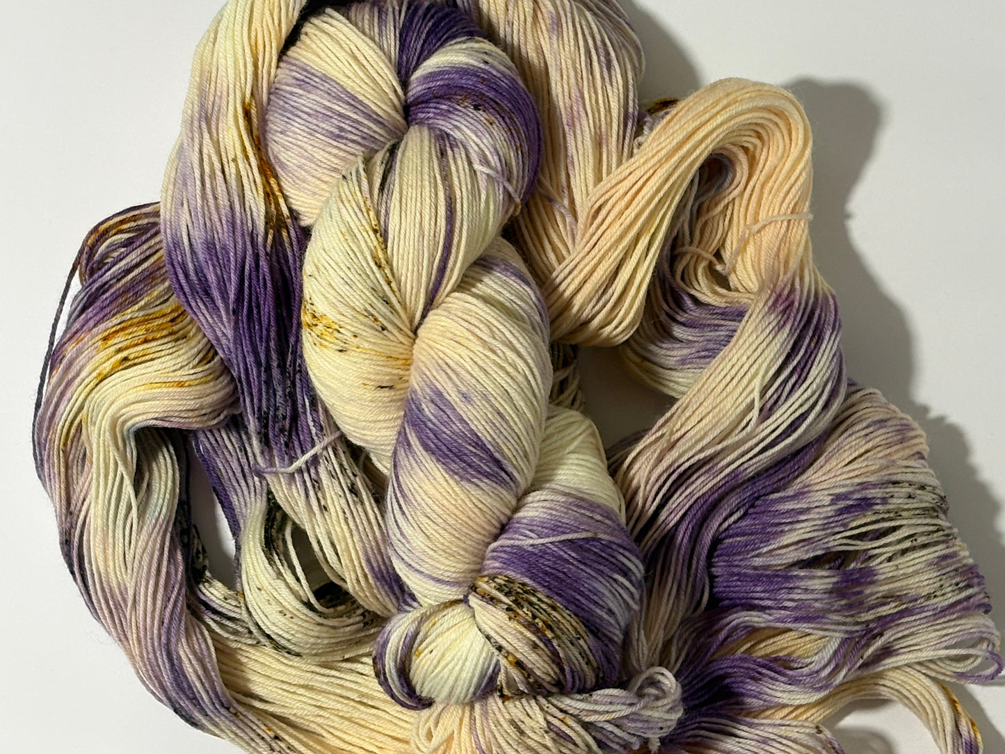 A luminous cream hand-dyed yarn brushed with soft lilac and delicate golden speckles. Enchanted Winterlight captures the quiet magic of winter light through old glass.