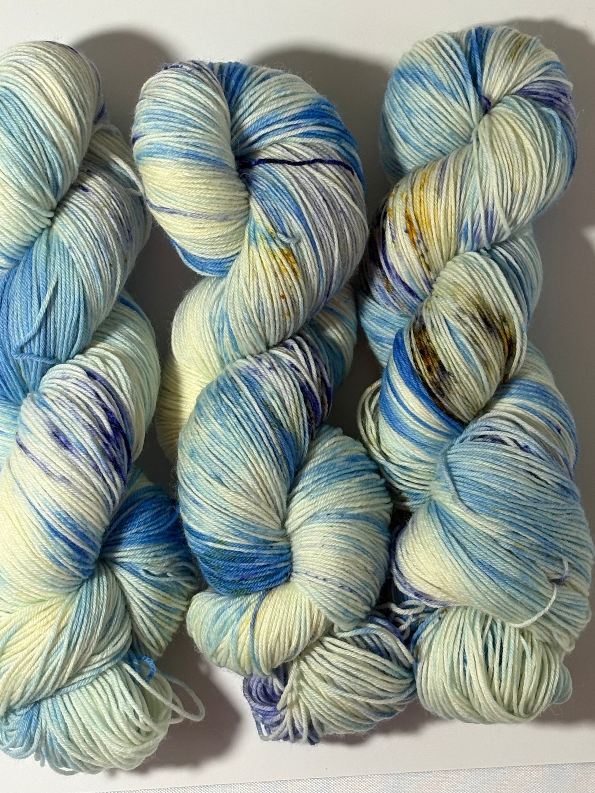 A softly speckled winter hand-dyed yarn colorway inspired by quiet woodland paths dusted with frost and snow.
