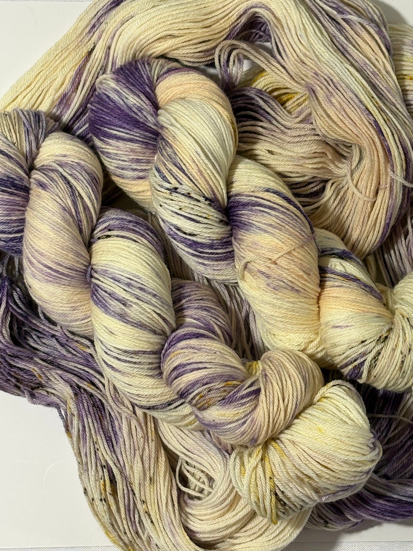 A luminous cream base multicolored hand-dyed yarn brushed with soft lilac and delicate golden speckles. Enchanted Winterlight captures the quiet magic of winter light through old glass.