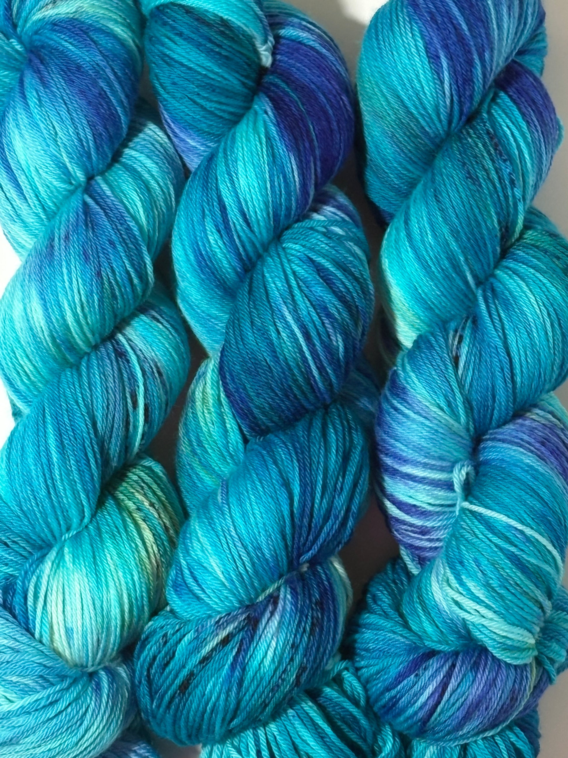 A flowing blend of teal, aqua, and deep blue multicolored hand-dyed yarn inspired by winter rivers at dusk. Winter Twilight River is cool, dynamic, and full of movement.