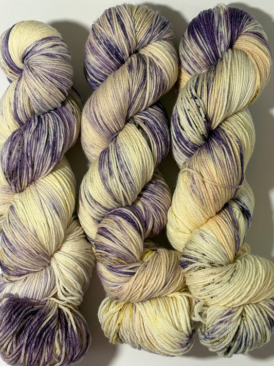 A luminous cream base multicolored hand-dyed yarn brushed with soft lilac and delicate golden speckles. Enchanted Winterlight captures the quiet magic of winter light through old glass.