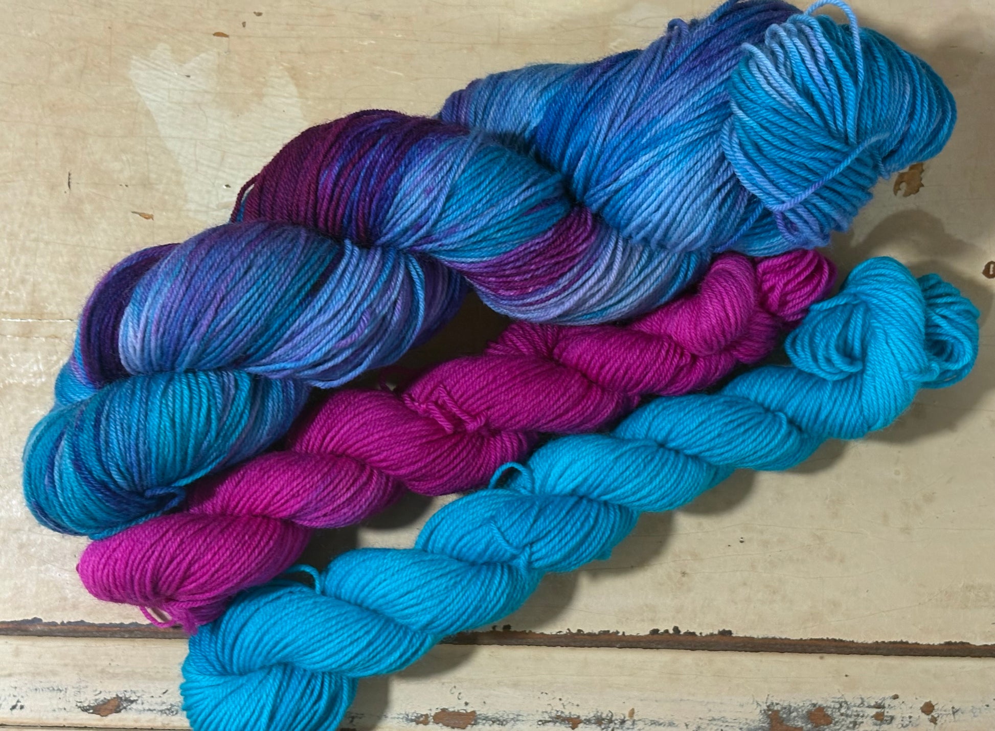 Discover the Arctic Frost Sock Set — a hand-dyed multicolored blue and purple yarn paired with one pink and one blue tonal mini skein by The Curious Skein. Small batch, luxury merino nylon blend in fingering weight yarn for socks, shawls and other projects.