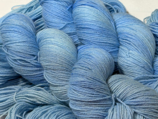 A soft icy blue hand-dyed tonal yarn inspired by frost-covered winter paths and quiet cold mornings.