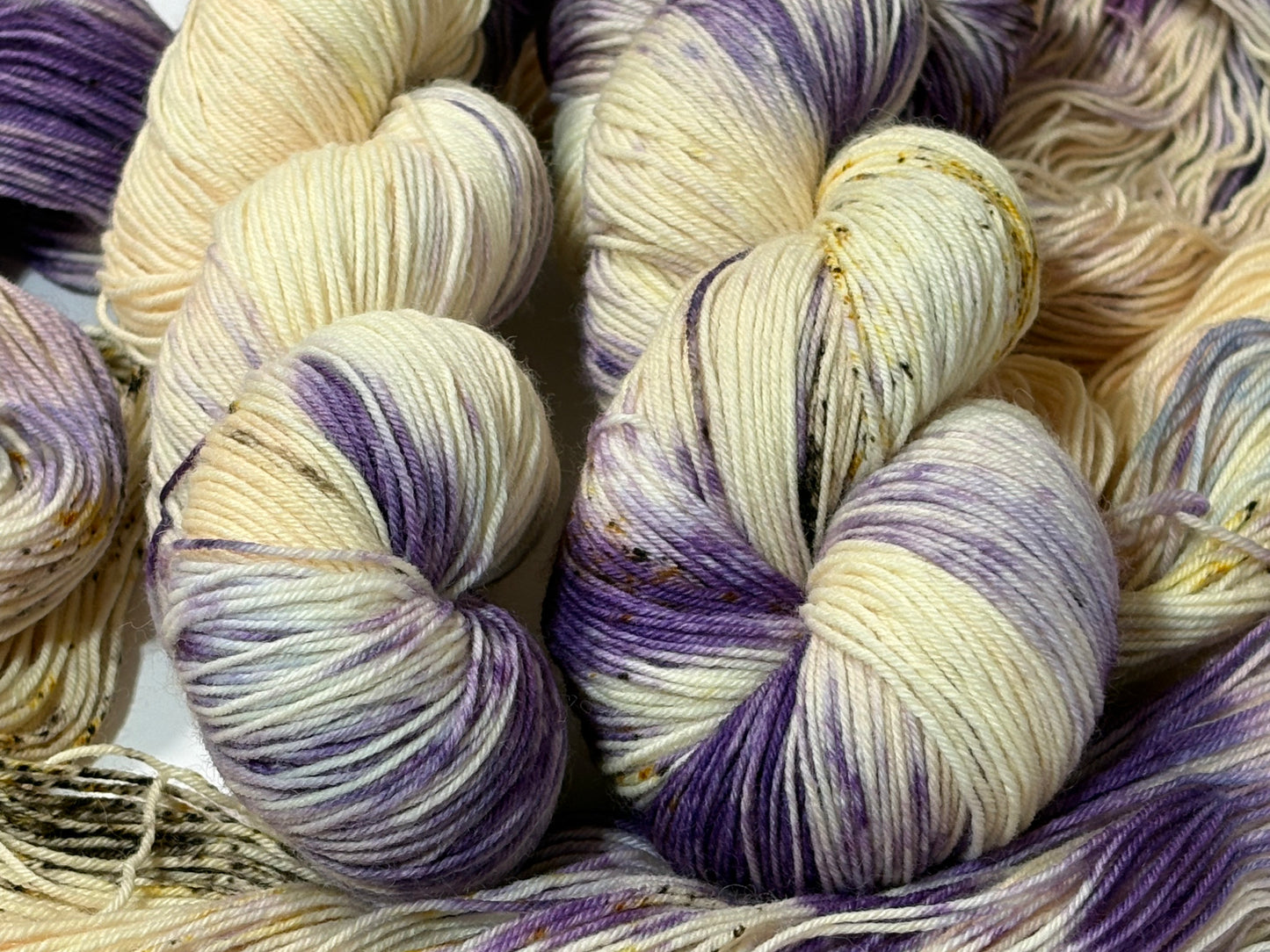 A luminous cream hand-dyed yarn brushed with soft lilac and delicate golden speckles. Enchanted Winterlight captures the quiet magic of winter light through old glass.