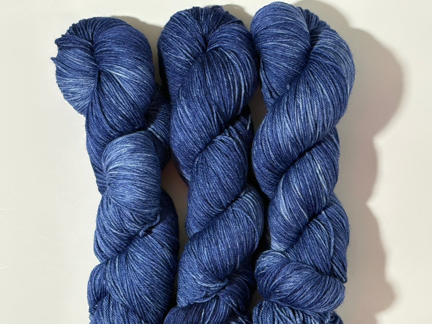 A deep, tonal blue hand-dyed yarn inspired by the quiet moment when daylight fades and night settles in.