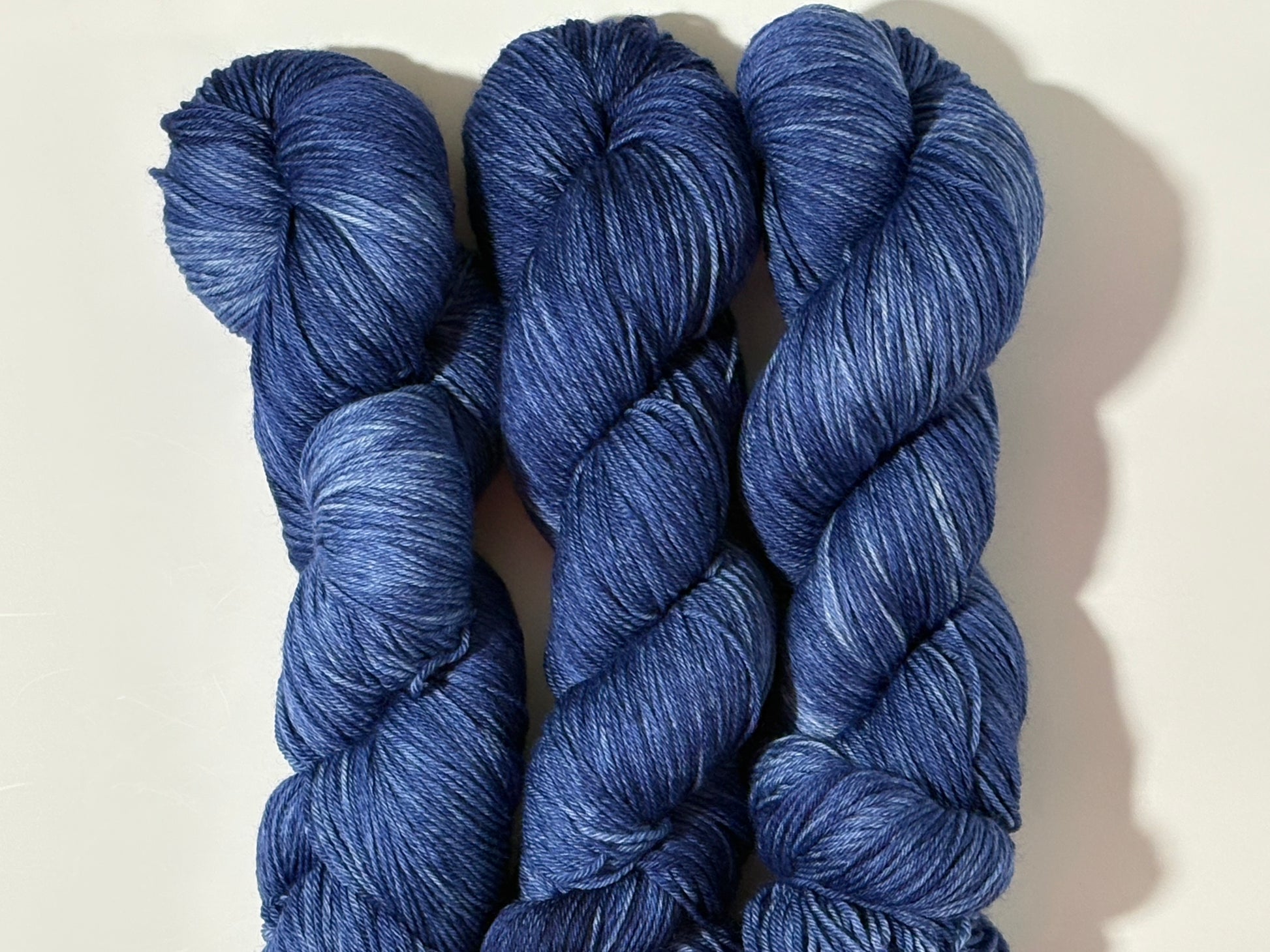 A deep, tonal blue hand-dyed yarn inspired by the quiet moment when daylight fades and night settles in.
