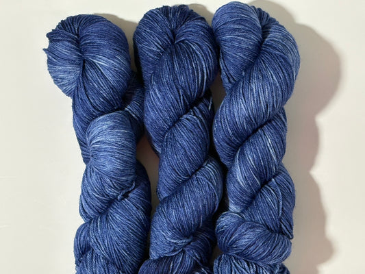 A deep, tonal blue hand-dyed yarn inspired by the quiet moment when daylight fades and night settles in.