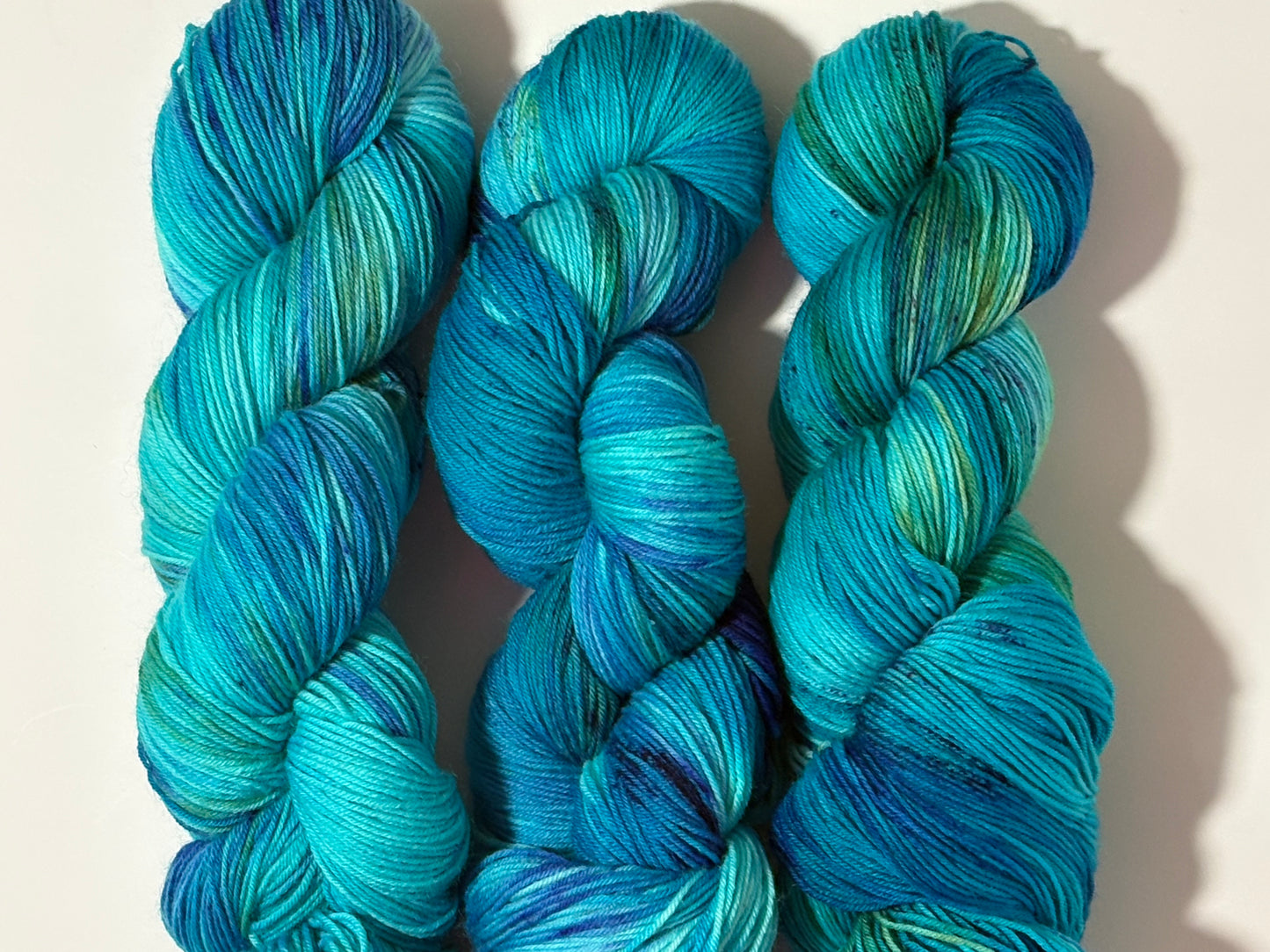 A flowing blend of teal, aqua, and deep blue inspired by winter rivers at dusk. Winter Twilight River is a hand-dyed yarn that is cool, dynamic, and full of movement.