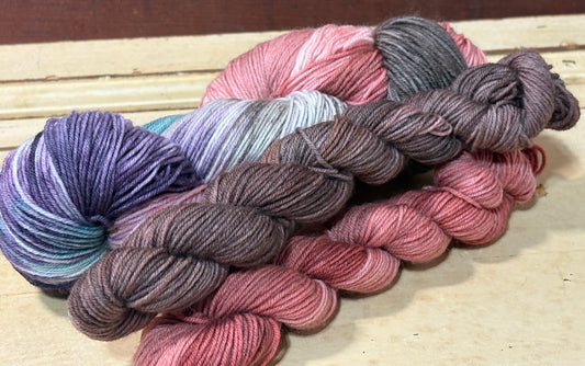 Discover the Cider Season Sock Set — a hand-dyed multicolored autumnal yarn paired with one amber and one brown tonal mini skein by The Curious Skein. Small batch, luxury merino nylon blend in fingering weight yarn for socks, shawls and other projects.