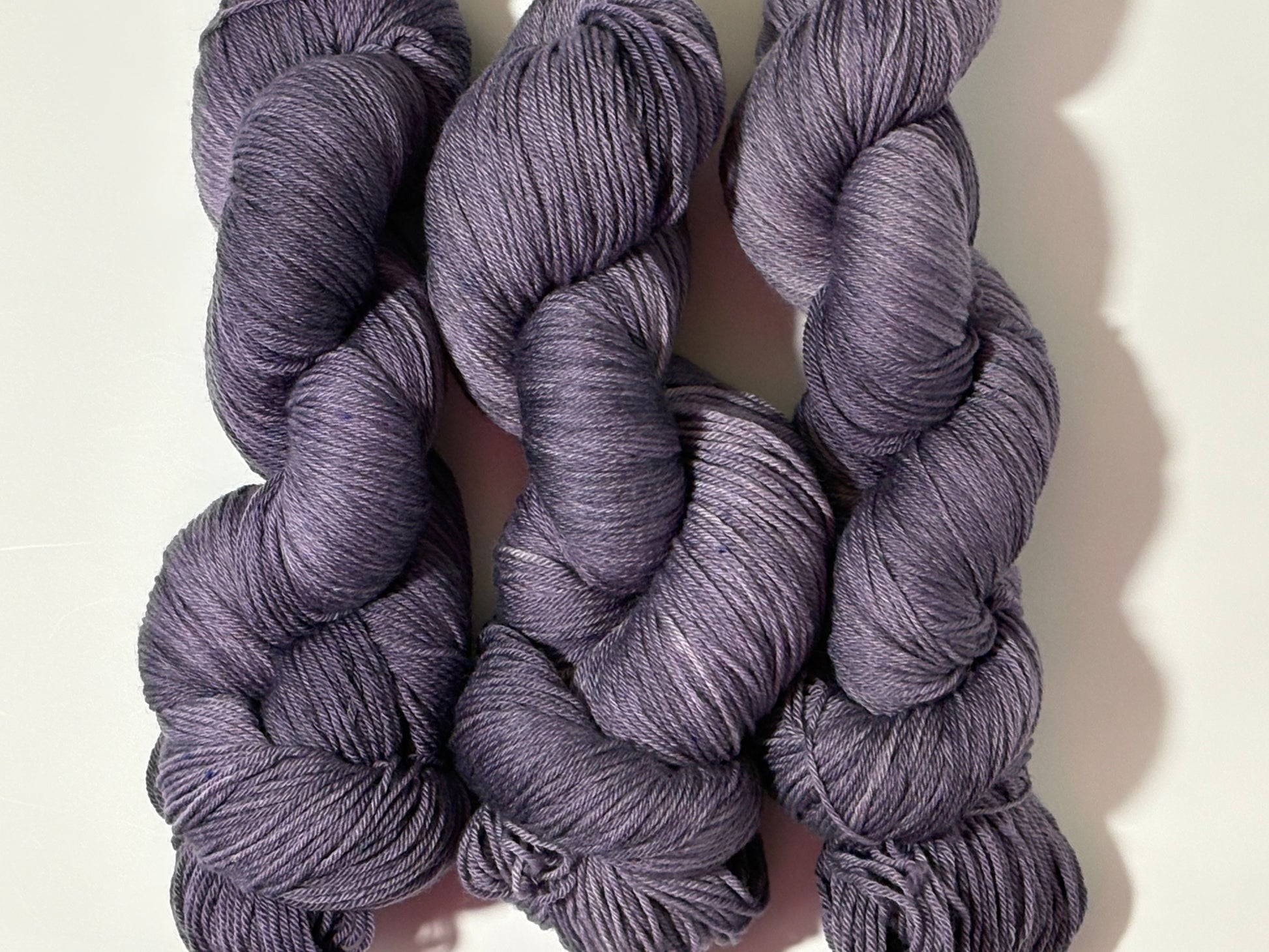 A smoky, softened violet hand-dyed tonal yarn with subtle gray undertones, Nightfall Violet captures the hush of dusk as daylight fades into evening. Calm, contemplative, and endlessly wearable.