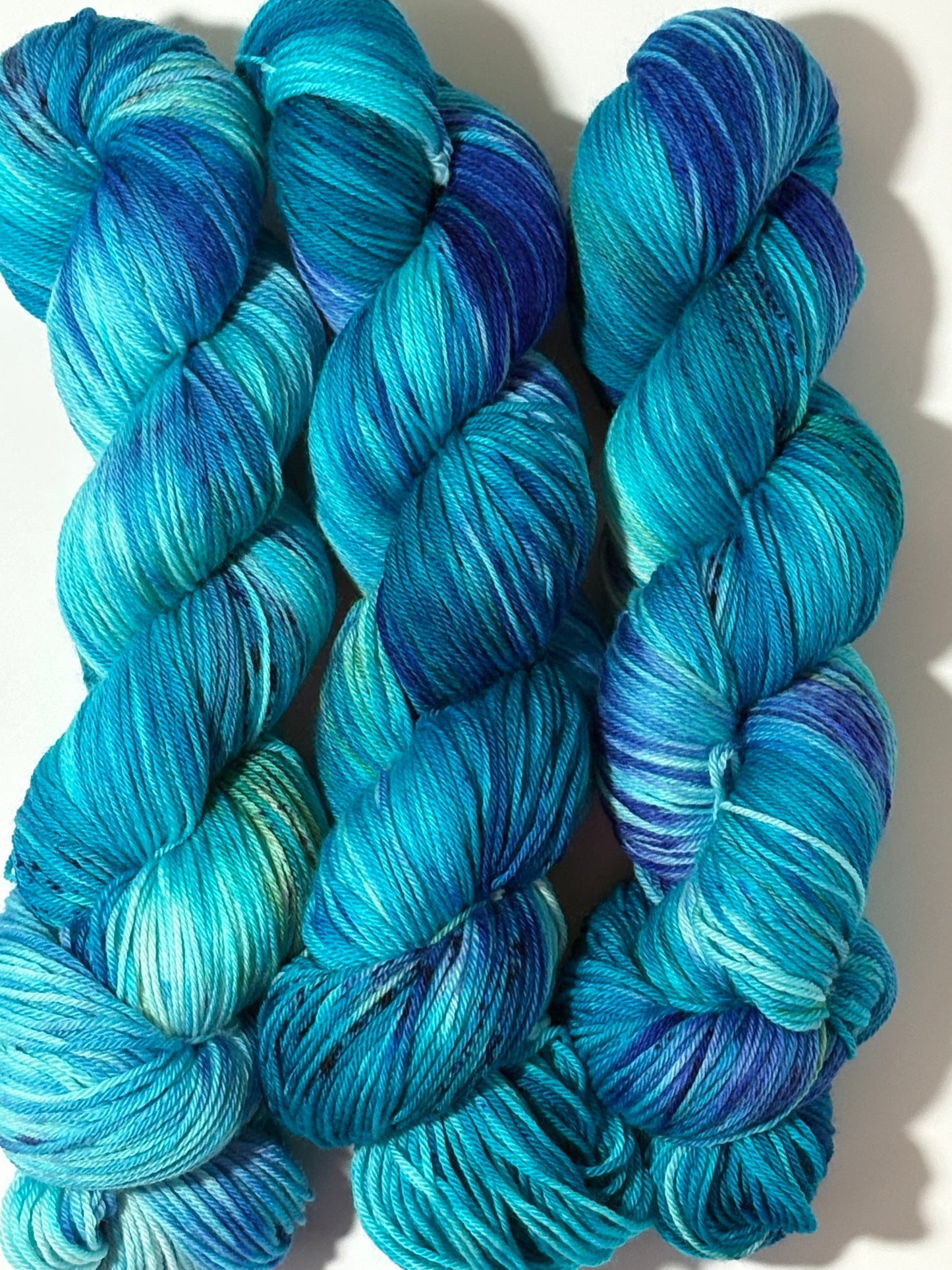 A flowing blend of teal, aqua, and deep blue multicolored hand-dyed yarn inspired by winter rivers at dusk. Winter Twilight River is cool, dynamic, and full of movement.