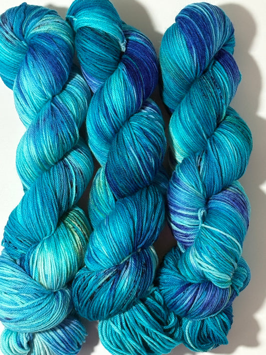 A flowing blend of teal, aqua, and deep blue multicolored hand-dyed yarn inspired by winter rivers at dusk. Winter Twilight River is cool, dynamic, and full of movement.
