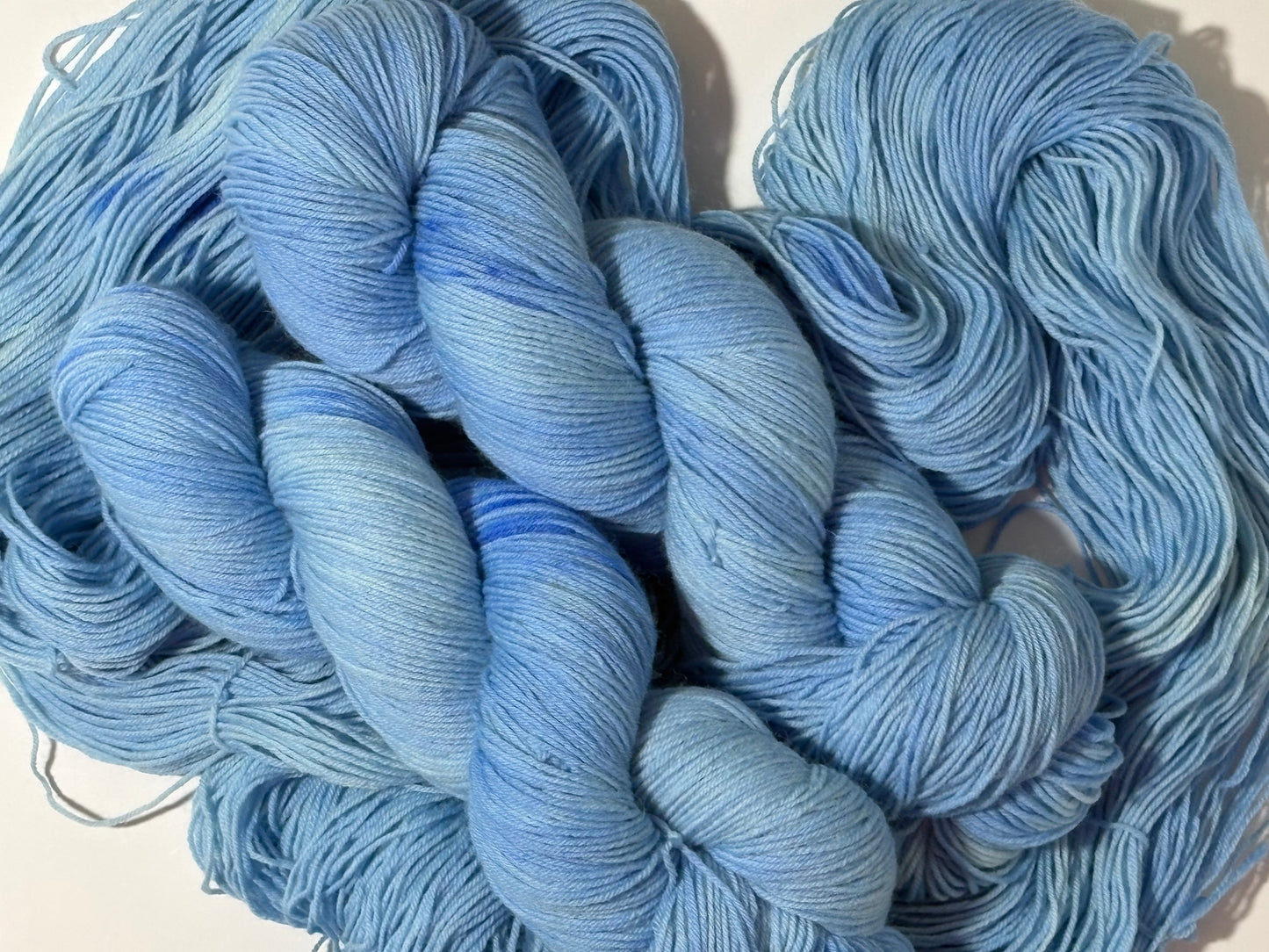 A soft icy blue hand-dyed tonal yarn inspired by frost-covered winter paths and quiet cold mornings.