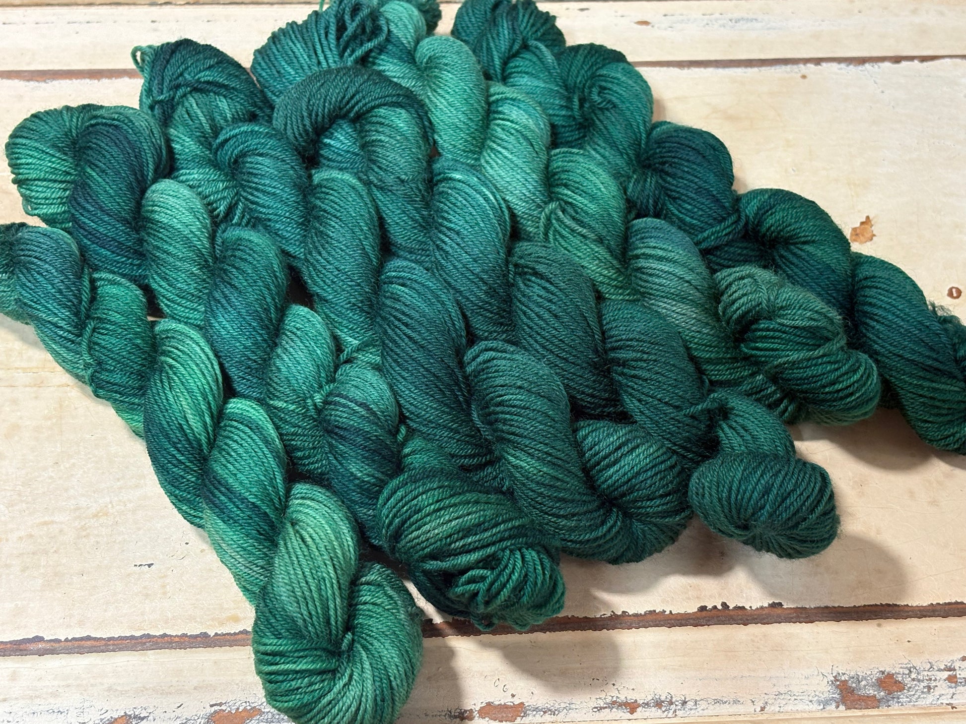 Discover Evergreen Glow — a hand-dyed tonal yarn mini skein by The Curious Skein. Small batch, luxury merino wool fingering weight yarn for knitting and crochet.