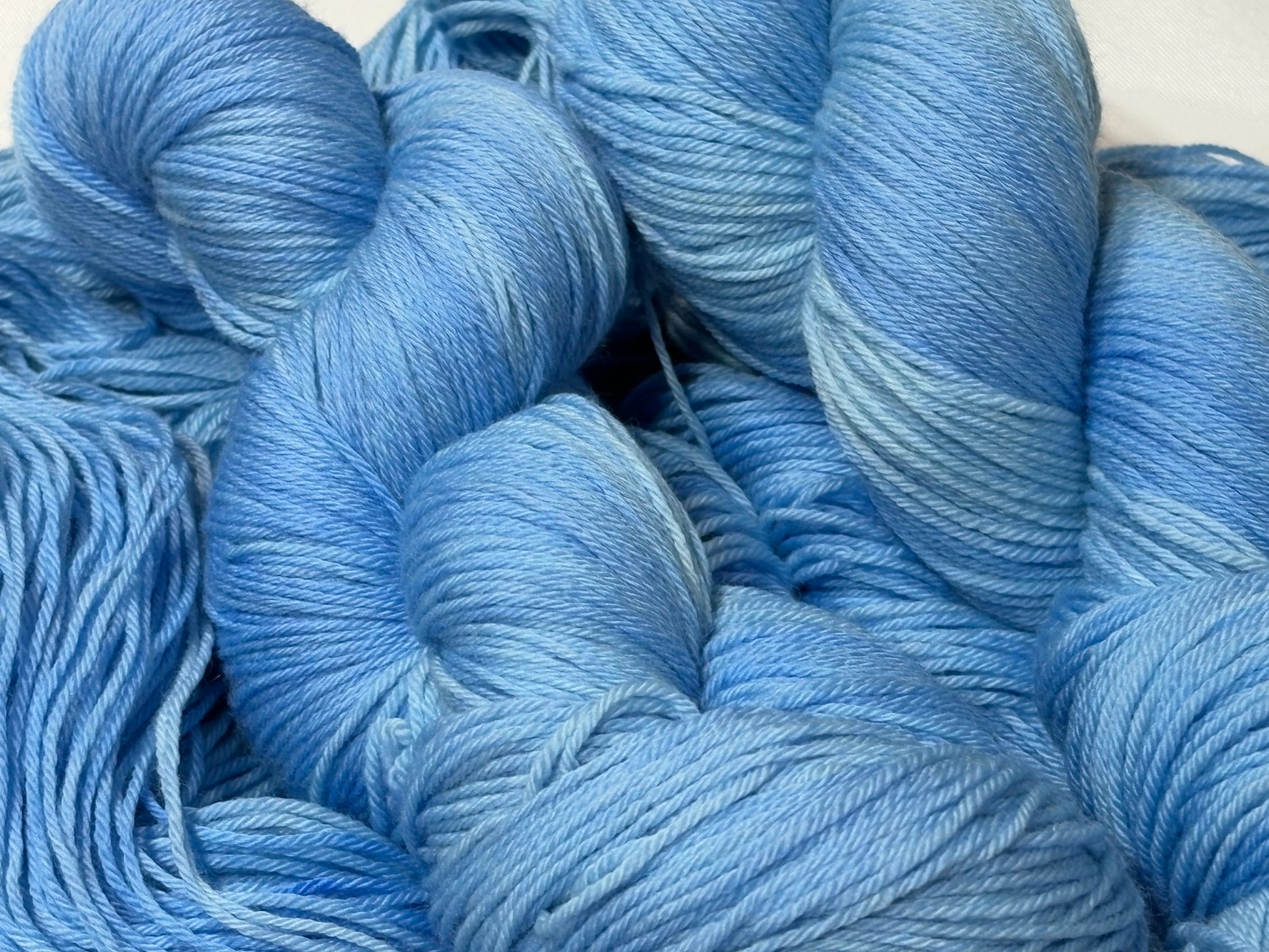 A soft icy blue hand-dyed tonal yarn inspired by frost-covered winter paths and quiet cold mornings.