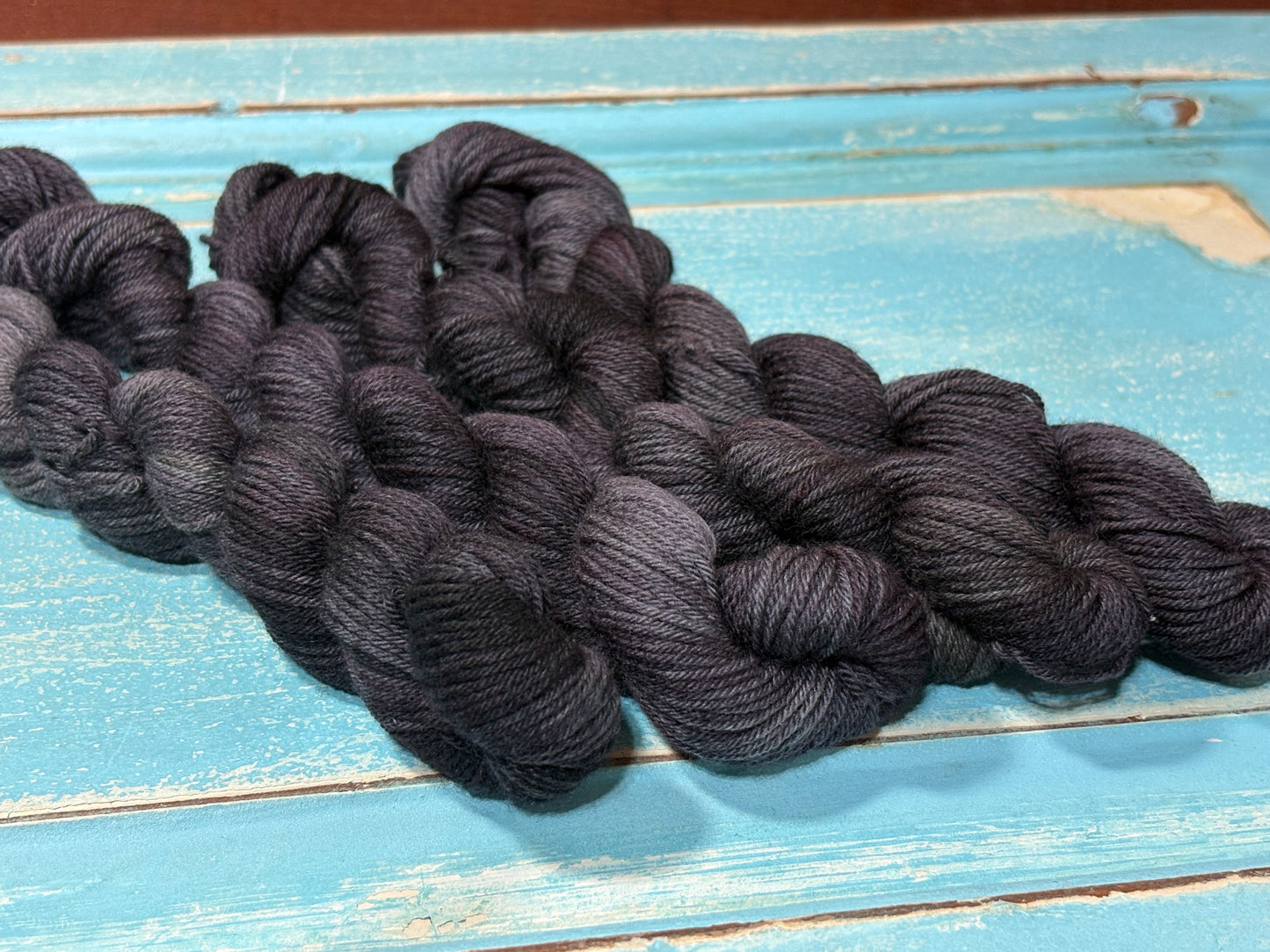 Graphite Bloom by The Curious Skein — a one-of-a-kind hand-dyed yarn. Unique small batch merino nylon fingering weight artisan yarn for knit and crochet.