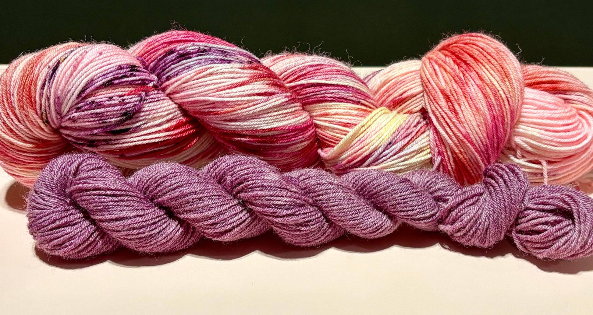 Hand-dyed sock set featuring soft blush pink, peach, cream, and berry tones with delicate wine and olive speckles paired with a dusty mauve tonal mini skein.