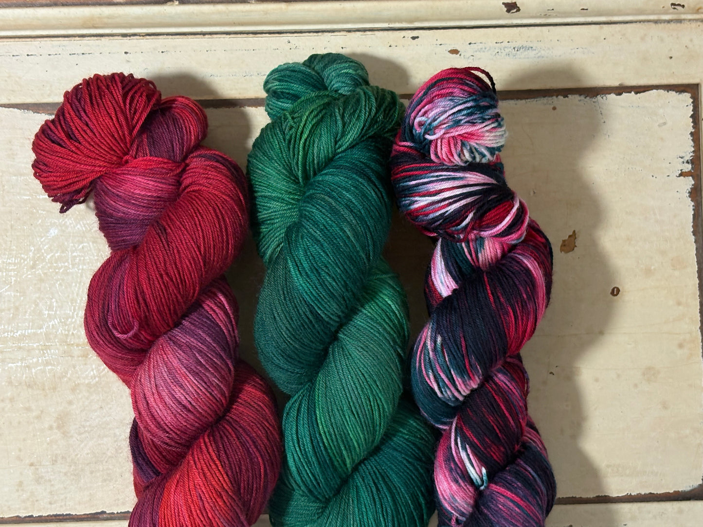 Winterberry Red, Evergreen Glow and Winterberry Garland by The Curious Skein — indie dyed tonal and multicolored yarns inspired by the magic of holiday color. Hand-dyed merino nylon fingering weight for knitting and crochet.