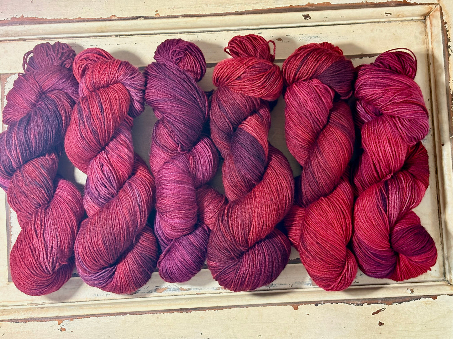 Discover Winterberry Red — a hand-dyed tonal yarn by The Curious Skein. Small batch, luxury merino wool fingering weight yarn for knitting and crochet.