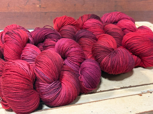 Discover Winterberry Red — a hand-dyed tonal yarn by The Curious Skein. Small batch, luxury merino wool fingering weight yarn for knitting and crochet.